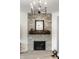 Close-up of living room fireplace with stone surround and wooden mantel at 3905 Pelham Rd, Carmel, IN 46074