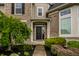 Up close shot of the main entrance featuring black front door, brick facade, and manicured landscaping at 3905 Pelham Rd, Carmel, IN 46074