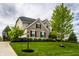 Traditional brick home featuring a well-kept lawn and a basketball hoop on the driveway at 3905 Pelham Rd, Carmel, IN 46074