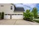 Three car garage with white doors, black hardware, and a concrete driveway at 3905 Pelham Rd, Carmel, IN 46074