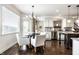Bright eat-in kitchen boasts stainless appliances, dark wood floors, and an eye-catching chandelier at 3905 Pelham Rd, Carmel, IN 46074