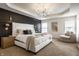Luxurious main bedroom with tray ceiling, paneled accent wall and a sitting area at 3905 Pelham Rd, Carmel, IN 46074