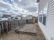 Fenced backyard with a stone patio and neighboring houses under a cloudy sky at 3941 Planewood Dr, Indianapolis, IN 46235