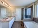 Bathroom featuring double sinks, tiled shower, and a tub, offering a luxurious space at 3941 Planewood Dr, Indianapolis, IN 46235