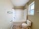 Standard bathroom with a single sink, toilet, and shower-tub combo with white tile surround at 3941 Planewood Dr, Indianapolis, IN 46235