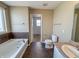 Bathroom with a tub, toilet, sink, and tiled floors and walls, offering functionality and style at 3941 Planewood Dr, Indianapolis, IN 46235
