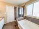 Well-lit bathroom featuring a glass shower, bathtub, and a convenient door access at 3941 Planewood Dr, Indianapolis, IN 46235