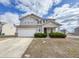 Two-story home featuring an attached garage, lush shrubbery, and a driveway with ample parking space at 3941 Planewood Dr, Indianapolis, IN 46235
