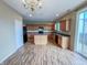 Well-lit kitchen with wood-look flooring, wooden cabinets, functional island, and stainless steel appliances at 3941 Planewood Dr, Indianapolis, IN 46235
