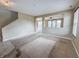 Open living room showcasing neutral walls, staircase, carpet, and an opening into the dining room at 3941 Planewood Dr, Indianapolis, IN 46235