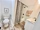 Cozy bathroom featuring a toilet, tub/shower with black hardware, and wood look floor at 4224 Cornelius Ave, Indianapolis, IN 46208