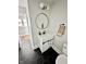 Bathroom with a hexagon tile floor, single sink vanity and a round mirror at 4224 Cornelius Ave, Indianapolis, IN 46208