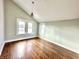 Bedroom featuring hardwood floors, a vaulted ceiling, windows, and light-colored walls at 4224 Cornelius Ave, Indianapolis, IN 46208