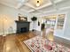 Bright living room featuring a fireplace, coffered ceilings, and hardwood floors with decorative rug at 4224 Cornelius Ave, Indianapolis, IN 46208