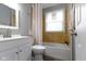 Cozy bathroom with tiled walls, a bathtub, and modern fixtures at 4457 N Kenmore Rd, Indianapolis, IN 46226