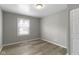 A clean and bright bedroom features hard wood flooring and natural light from a large window at 4457 N Kenmore Rd, Indianapolis, IN 46226