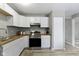Well-lit kitchen featuring white cabinets, stainless steel appliances, and ample counter space at 4457 N Kenmore Rd, Indianapolis, IN 46226