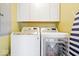 Laundry room with washer, dryer, storage cabinets, and ironing board at 5055 Willow Rd, Zionsville, IN 46077