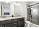Modern bathroom featuring a double vanity with granite counters and a tiled walk-in shower at 606 E 10Th St, Indianapolis, IN 46202