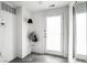 Bright foyer with a white door, gray tile flooring, and a coat rack with a stylish hat and bag at 606 E 10Th St, Indianapolis, IN 46202