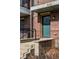 Close-up of a townhouse front entrance with concrete steps, brick wall, and a black-framed door at 606 E 10Th St, Indianapolis, IN 46202