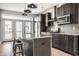 A modern kitchen with stainless steel appliances, a granite countertop island, and a door leading to a balcony at 606 E 10Th St, Indianapolis, IN 46202