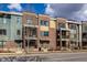 Attractive townhomes feature brick and siding exteriors and wrought iron railings, under a cloudy sky at 606 E 10Th St, Indianapolis, IN 46202