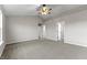 Large bedroom with a ceiling fan, neutral walls, plush carpeting and two entry doors at 6311 Feather Run Dr, Indianapolis, IN 46237