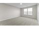 A bright bedroom with neutral carpet, paint, electrical outlets, and natural light streaming through a double window at 6311 Feather Run Dr, Indianapolis, IN 46237