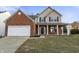 Charming two-story home with a two-car garage, brick accents, and inviting front porch at 6311 Feather Run Dr, Indianapolis, IN 46237