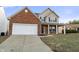 Beautiful two-story home featuring a brick facade, covered porch, and well-maintained lawn at 6311 Feather Run Dr, Indianapolis, IN 46237