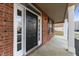 Close-up of the front door with sidelights, brick surround, and a covered porch area at 6311 Feather Run Dr, Indianapolis, IN 46237