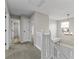 Upstairs hallway with plush carpet, white railing, and a view of the home's entryway at 6311 Feather Run Dr, Indianapolis, IN 46237