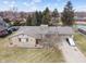 Elevated view of property with stone exterior and attached garage, with long driveway at 6412 Lava Ct, Indianapolis, IN 46237