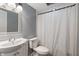 Compact bathroom with a gray wall, a mosaic-framed mirror, and a shower with curtain at 6412 Lava Ct, Indianapolis, IN 46237