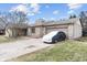 Angle view of the stone-accented house, highlighting the attached garage and well-kept lawn and covered vehicle at 6412 Lava Ct, Indianapolis, IN 46237