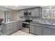 Charming kitchen with stainless steel appliances and grey cabinets at 6412 Lava Ct, Indianapolis, IN 46237