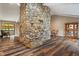 Spacious living room with hardwood floors, a stone fireplace and large windows providing natural light at 6412 Lava Ct, Indianapolis, IN 46237