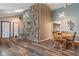 Open floor plan showcasing a stone fireplace, hardwood floors, and modern lighting fixtures in the dining area at 6412 Lava Ct, Indianapolis, IN 46237