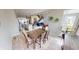 Open concept dining room features a wooden table with hardwood floors flowing into a kitchen and living area at 6481 W Treeline Ln, McCordsville, IN 46055