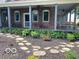 Inviting front porch with chairs, stone walkway and meticulously landscaped flowerbeds add charm to this lovely brick home at 695 N 650 W, Lebanon, IN 46052