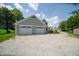 Detached garage with two bays, siding, and gravel driveway surrounded by greenery and a well maintained yard at 695 N 650 W, Lebanon, IN 46052