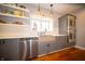 Modern kitchen featuring stainless steel appliances, open shelving, and a bright window above the sink at 695 N 650 W, Lebanon, IN 46052