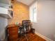 Home office with a brick accent wall, modern desk, and natural light from the window at 695 N 650 W, Lebanon, IN 46052