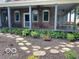 Charming porch with brick columns and a swing, surrounded by lush hostas and a stone pathway in a mulched garden at 695 N 650 W, Lebanon, IN 46052