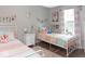 Charming bedroom with two beds, playful decor, wood floors, and a bright window at 7013 Ringtail Ct, Indianapolis, IN 46254