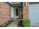 Inviting front entry with brick accents, manicured landscaping and hanging plants at 7013 Ringtail Ct, Indianapolis, IN 46254