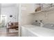 Bright laundry room with modern washer and dryer units, built-in shelving, and a view to the living room at 7013 Ringtail Ct, Indianapolis, IN 46254