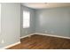 A cozy bedroom featuring wood floors, light blue walls, and a window with blinds at 7136 Allegan Dr, Indianapolis, IN 46217