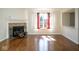 Cozy living room with a fireplace, hardwood floors, and natural light from a nearby window at 7136 Allegan Dr, Indianapolis, IN 46217